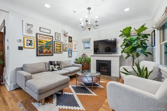 a living room with furniture a chandelier and a fireplace