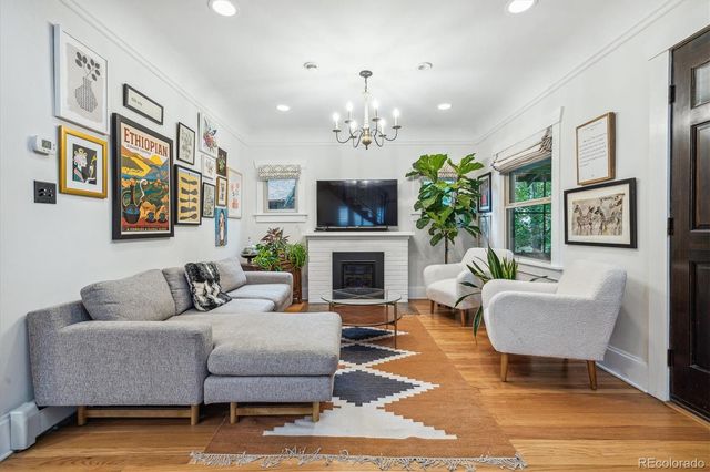 a living room with furniture a fireplace and a chandelier