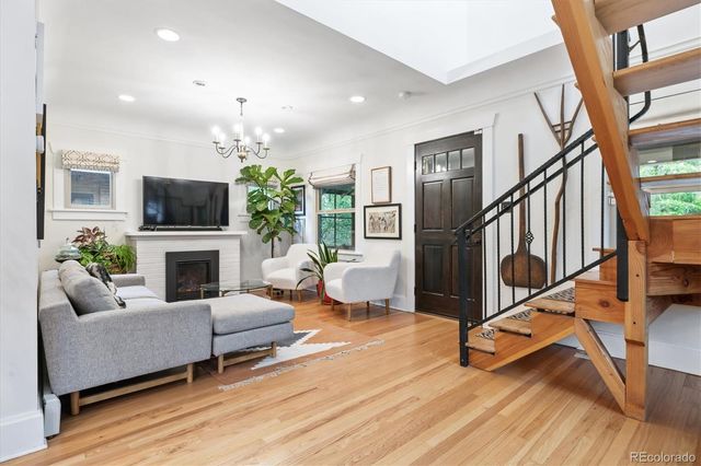 a living room with furniture a fireplace and a chandelier