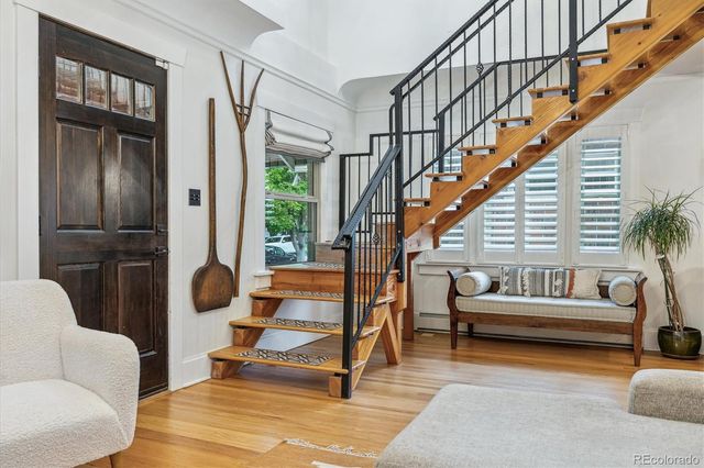 a living room with furniture and a dining table next to a large window