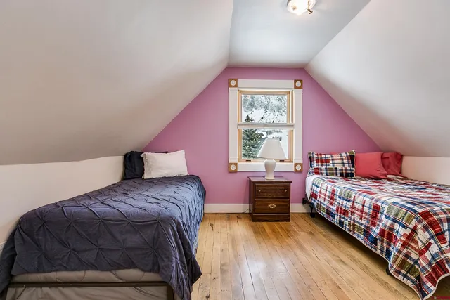 a view of a house with large tree and wooden fence