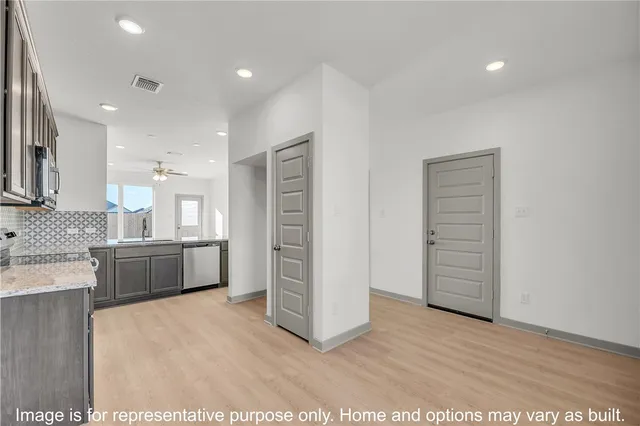 a large white kitchen with a sink and dishwasher a oven with wooden floor
