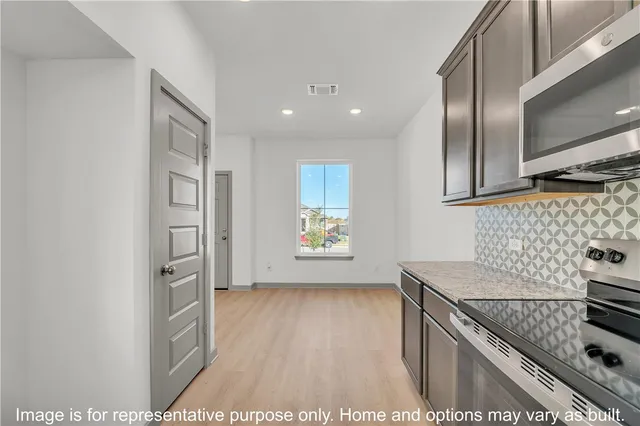 a kitchen with granite countertop a stove and a refrigerator