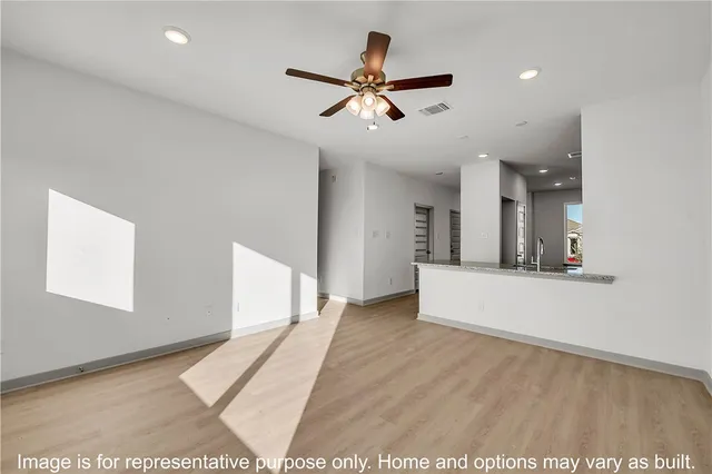 a view of a living room a ceiling fan and wooden floor