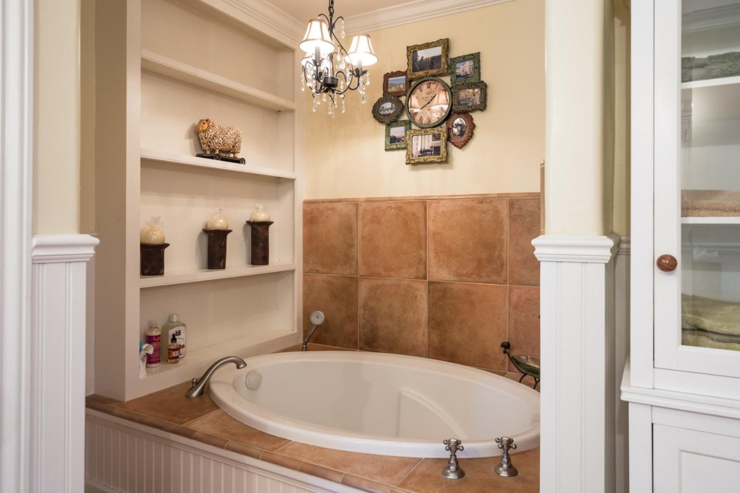 25064 Hatton Road Carmel, CA 93923 - Photo 16 of 21 a bathroom with a tub and a chandelier