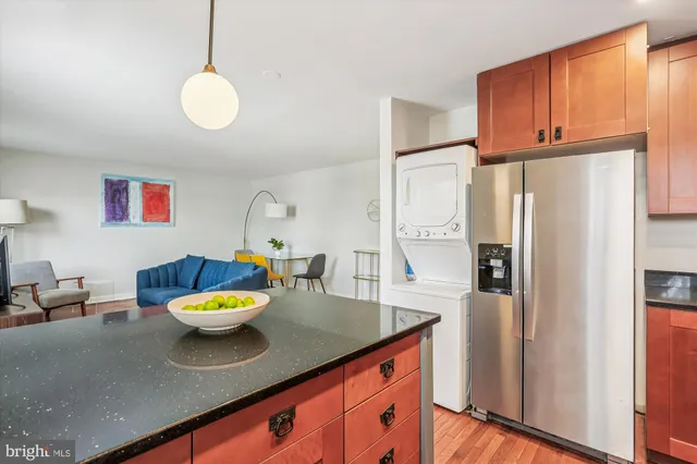 a kitchen with stainless steel appliances a sink a refrigerator and a wooden floor