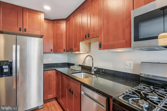 a kitchen with stainless steel appliances granite countertop a sink stove and refrigerator
