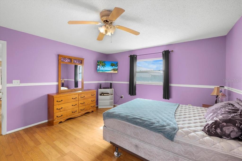 10290 Bannock Street Spring Hill, FL 34608 - Photo 14 of 40 a bedroom with a bed and a chandelier