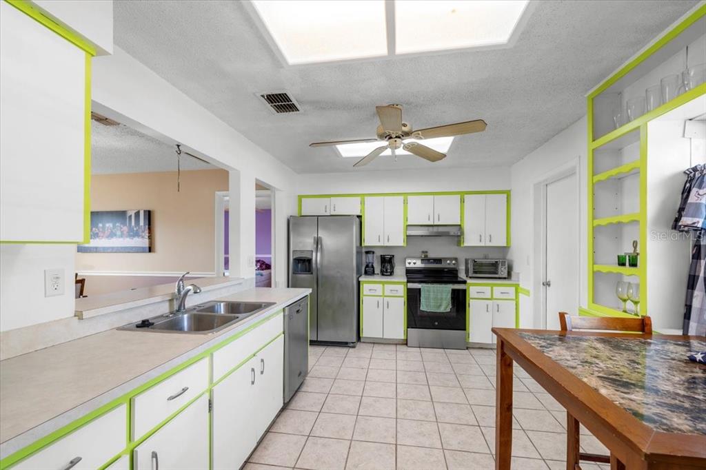10290 Bannock Street Spring Hill, FL 34608 - Photo 4 of 40 a large kitchen with a large counter top cabinets and stainless steel appliances