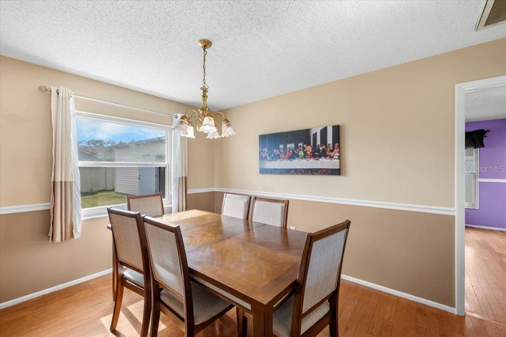 10290 Bannock Street Spring Hill, FL 34608 - Photo 8 of 40 a view of a dining room with furniture wooden floor and a chandelier