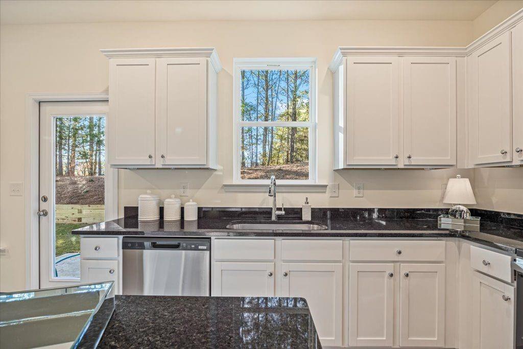 2555 Riverside Court Northeast Conyers, GA 30013 - Photo 12 of 33 a kitchen with granite countertop white cabinets and window