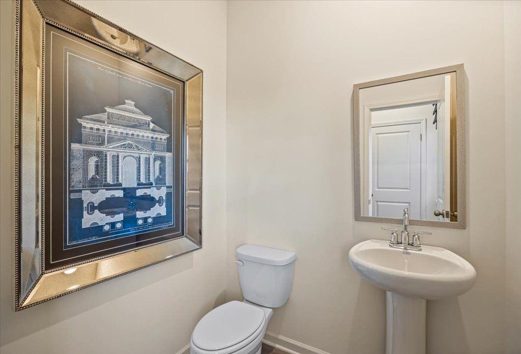 2555 Riverside Court Northeast Conyers, GA 30013 - Photo 14 of 33 a bathroom with a toilet a sink and mirror