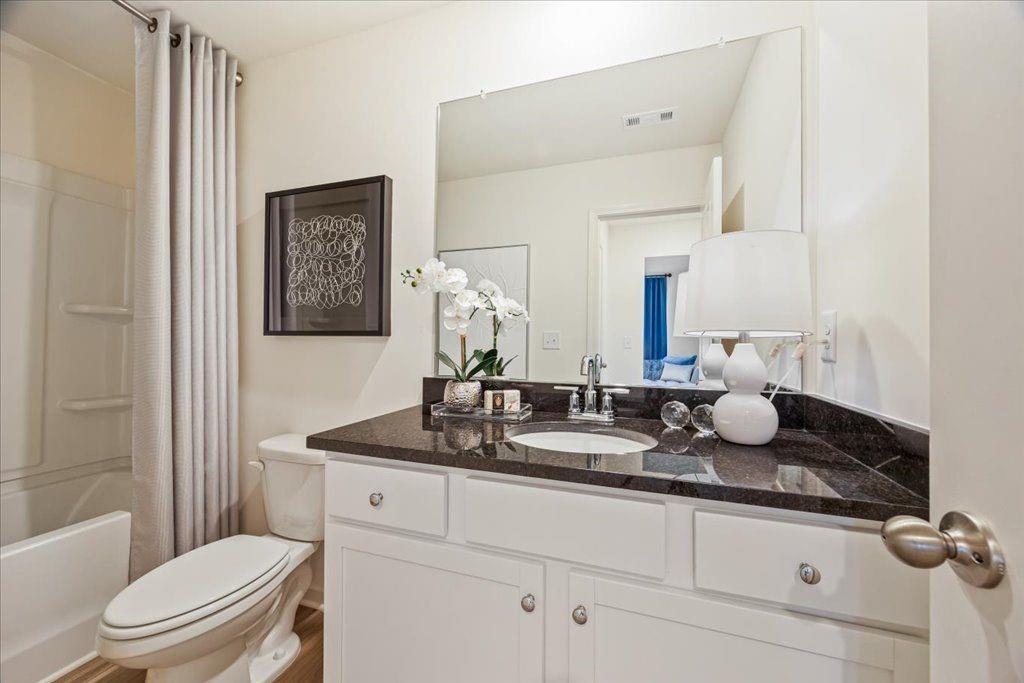 2555 Riverside Court Northeast Conyers, GA 30013 - Photo 20 of 33 a bathroom with a granite countertop sink a toilet and a mirror