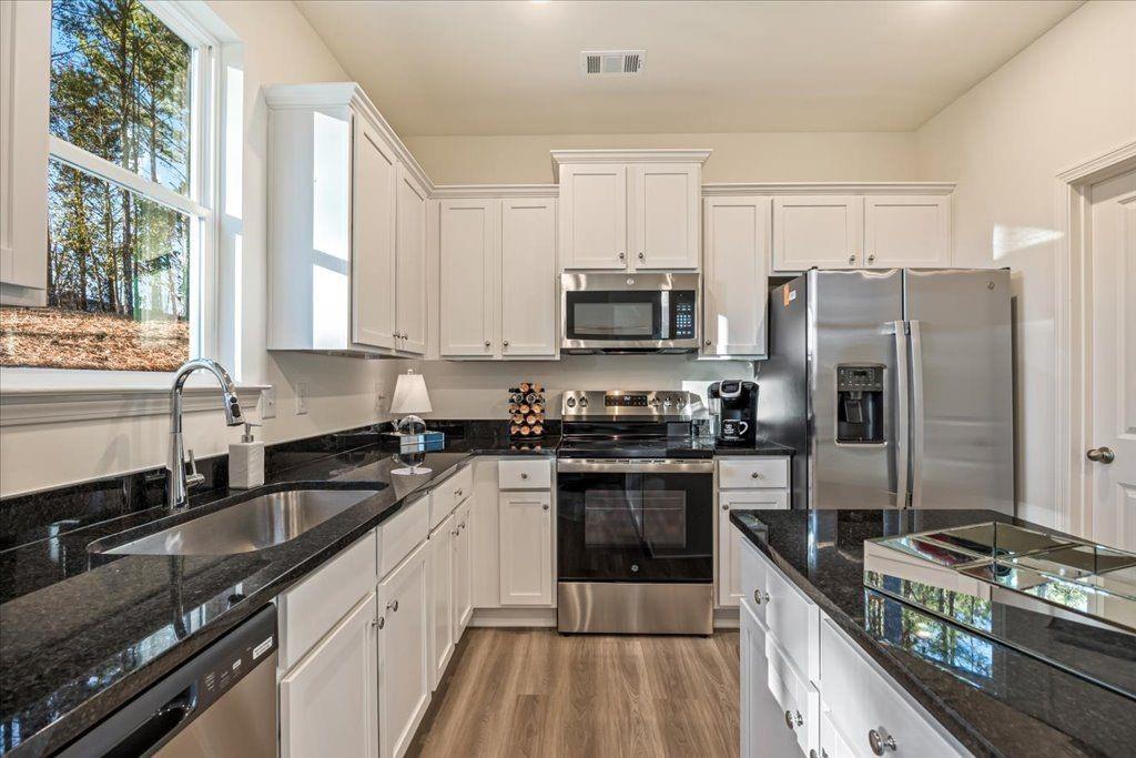 2555 Riverside Court Northeast Conyers, GA 30013 - Photo 10 of 33 a kitchen with a sink stove microwave and refrigerator