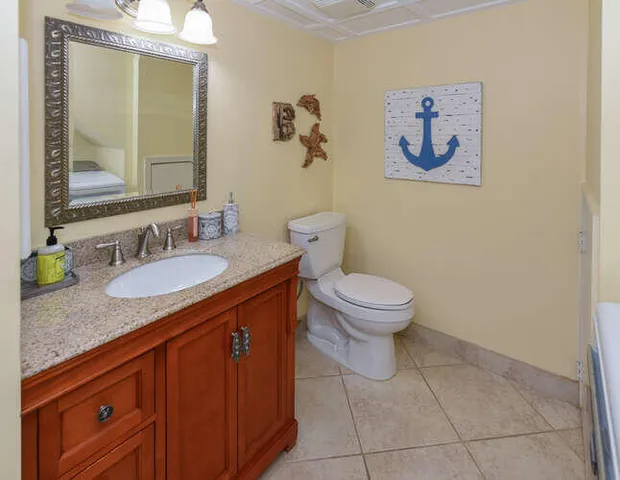 a bathroom with a granite countertop sink a toilet and a mirror