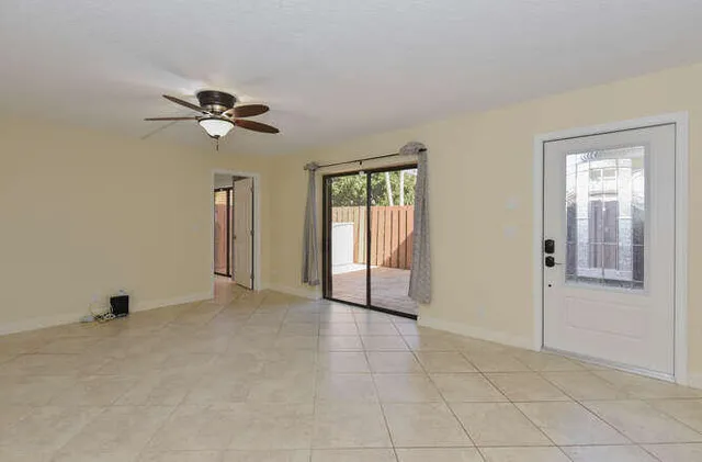 a view of a room with a ceiling fan and window