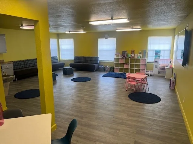 a living room with patio furniture and a wooden floor