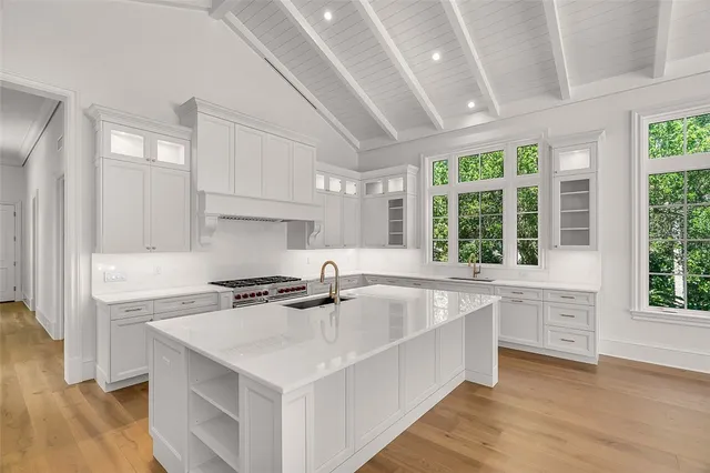 a kitchen that has a sink a stove and wooden floor