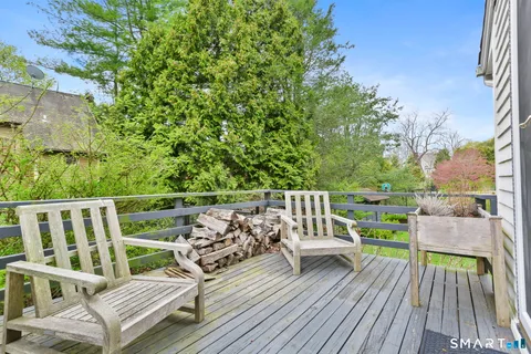 a view of deck with furniture and trees in the background