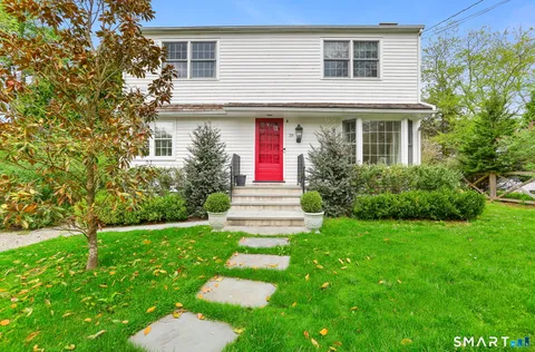 a front view of a house with a yard and trees