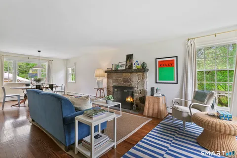 a living room with fireplace furniture and a large window