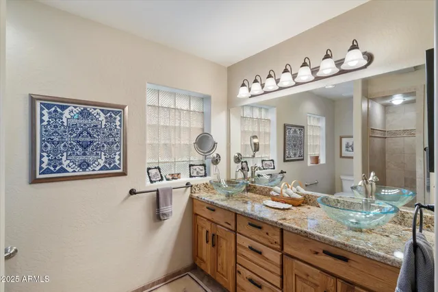 a bathroom with a sink double vanity granite and a mirror