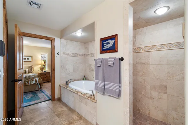 a bathroom with a tub a mirror and shower