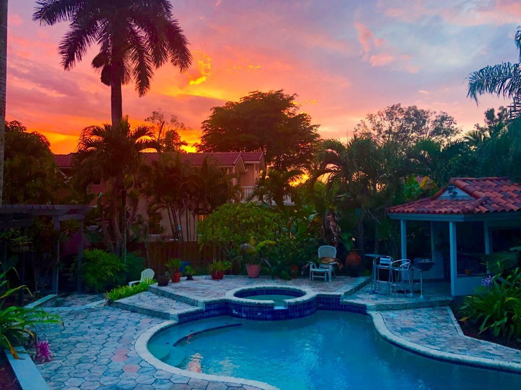 11081 Southwest 30th Court Davie, FL 33328 - Photo 1 of 29 a backyard of a house with table and chairs under an umbrella