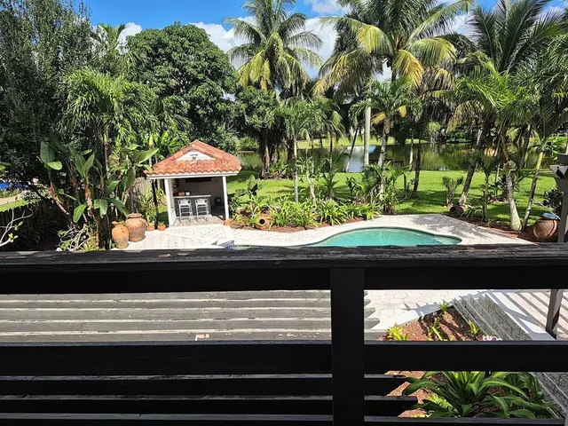 a view of a house with backyard and a tree