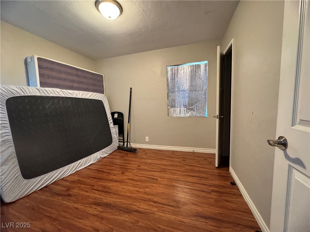 1409 Joshua Way Las Vegas, NV 89101 - Photo 11 of 15 Bedroom with dark wood-style floors and baseboards