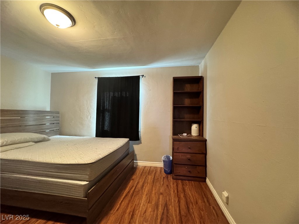 1409 Joshua Way Las Vegas, NV 89101 - Photo 13 of 15 Bedroom with dark wood-type flooring and baseboards