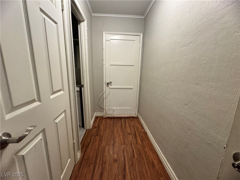 1409 Joshua Way Las Vegas, NV 89101 - Photo 6 of 15 Hallway featuring crown molding, dark wood finished floors, and a textured wall
