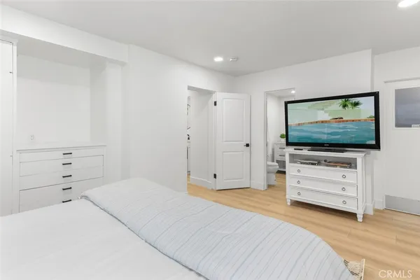 a bedroom with a bed and flat screen tv