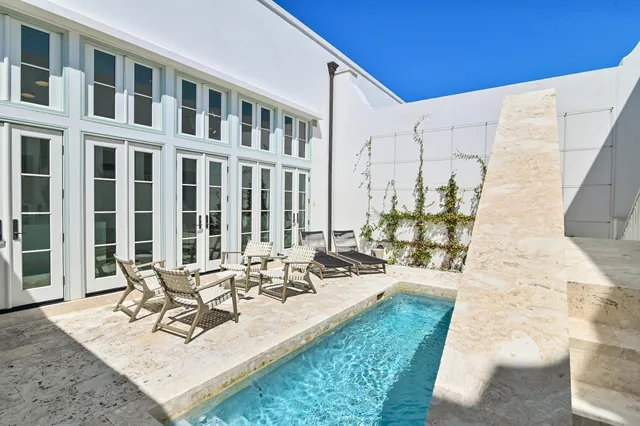 a view of a patio with couches table and chairs and potted plants