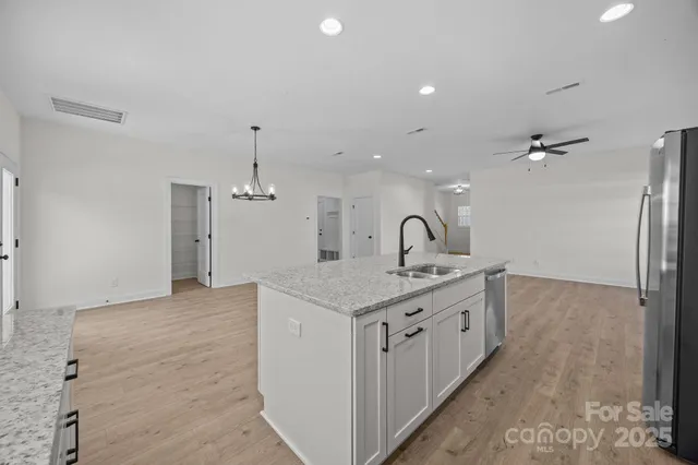 a spacious bathroom with a granite countertop sink a mirror and shower