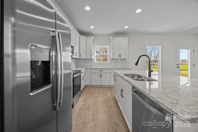 a kitchen with stainless steel appliances granite countertop a sink stove and refrigerator