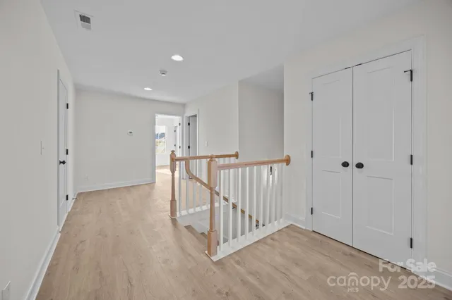 a view of a hallway with wooden floor and entryway