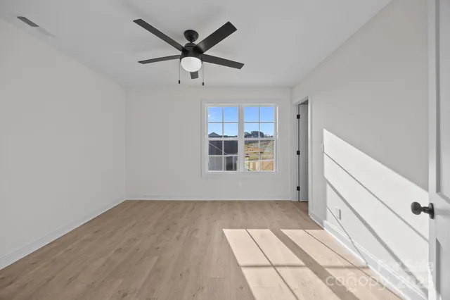 a view of a big room with wooden floor and windows