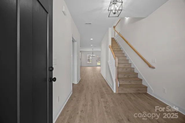 a view of a hallway with wooden floor and stairs