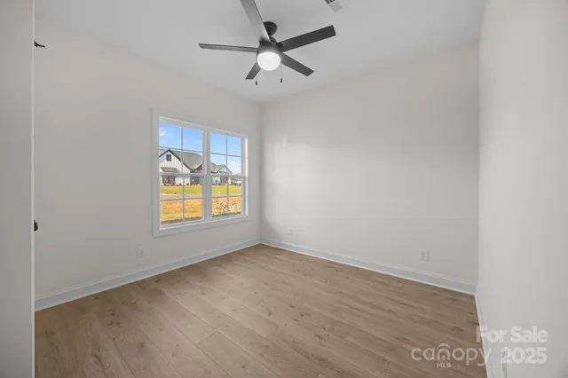 an empty room with a window and a fan