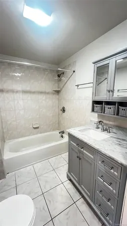 a bathroom with a granite countertop sink a mirror and bathtub