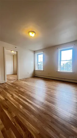 a view of a livingroom with wooden floor and window