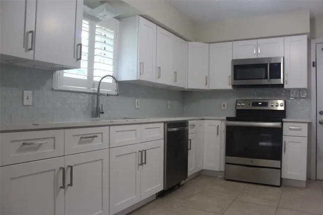 a kitchen with stainless steel appliances granite countertop a sink and a microwave