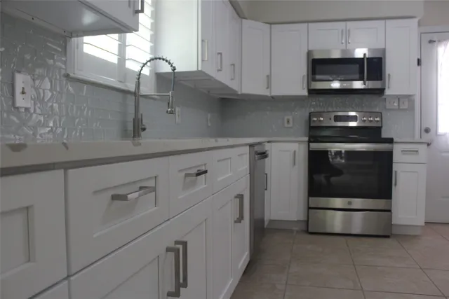 a view of a livingroom with a chandelier fan and wooden floor