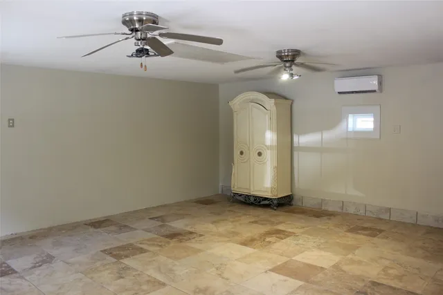 an empty room with a ceiling fan and a fan