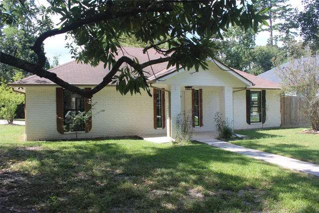 a front view of a house with a garden and yard