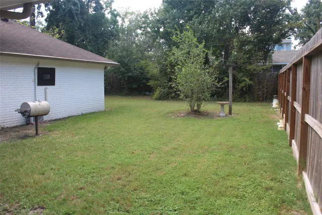 a view of a yard with wooden fence