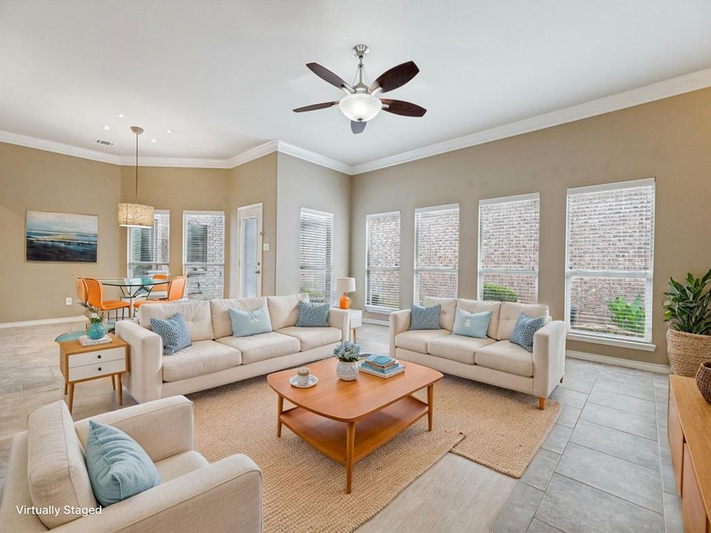 10032 Bell Rock Road Frisco, TX 75035 - Photo 4 of 23 Spacious living area featuring high ceilings, crown molding, a ceiling fan with integrated lighting, and multiple windows with blinds