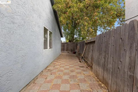 a pathway of a house with wooden fence