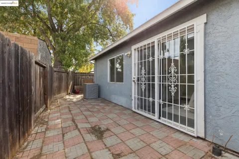 a view of backyard with large trees and wooden fence